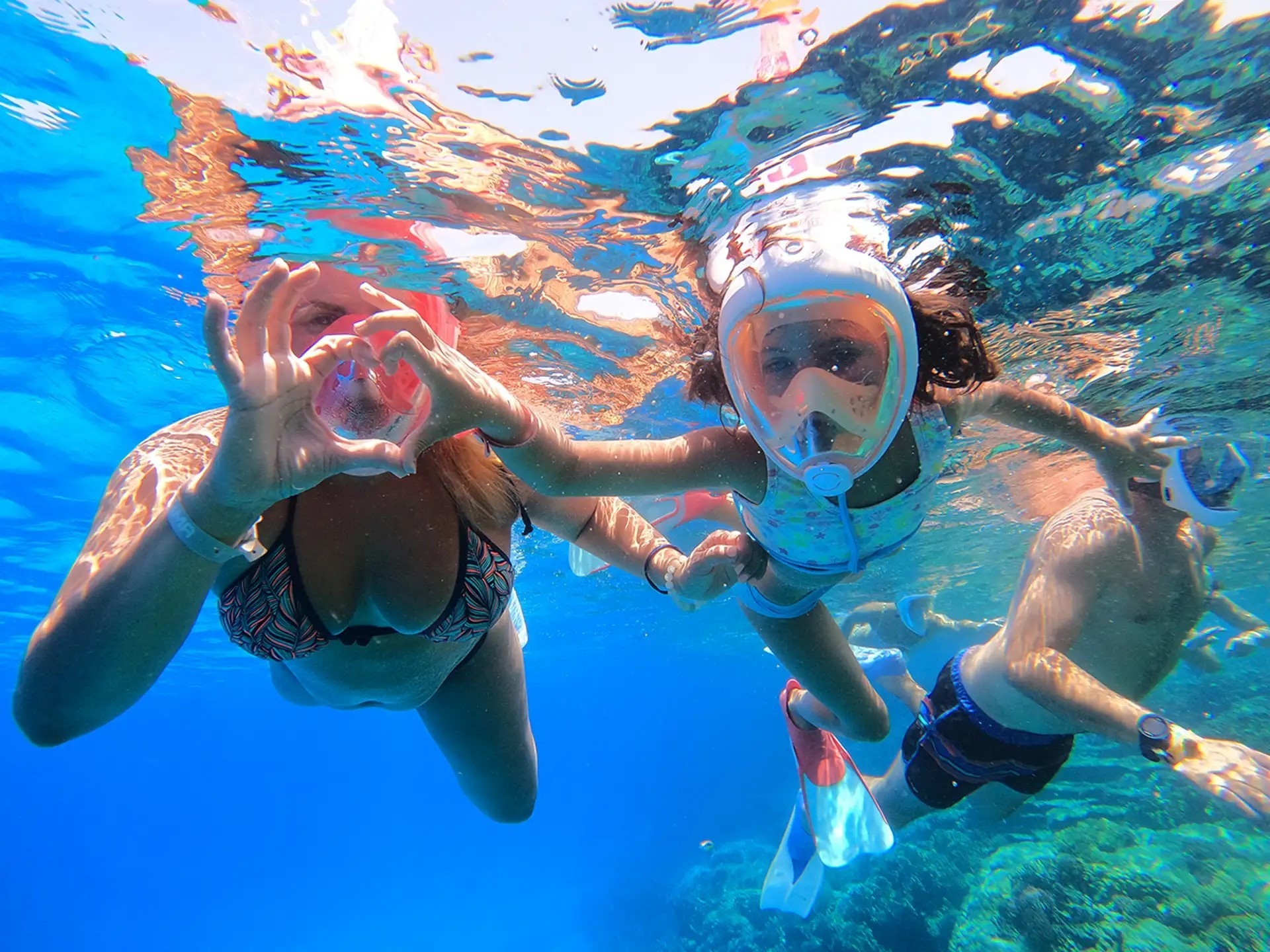 Couple standing in crystal-clear water at Orange Bay