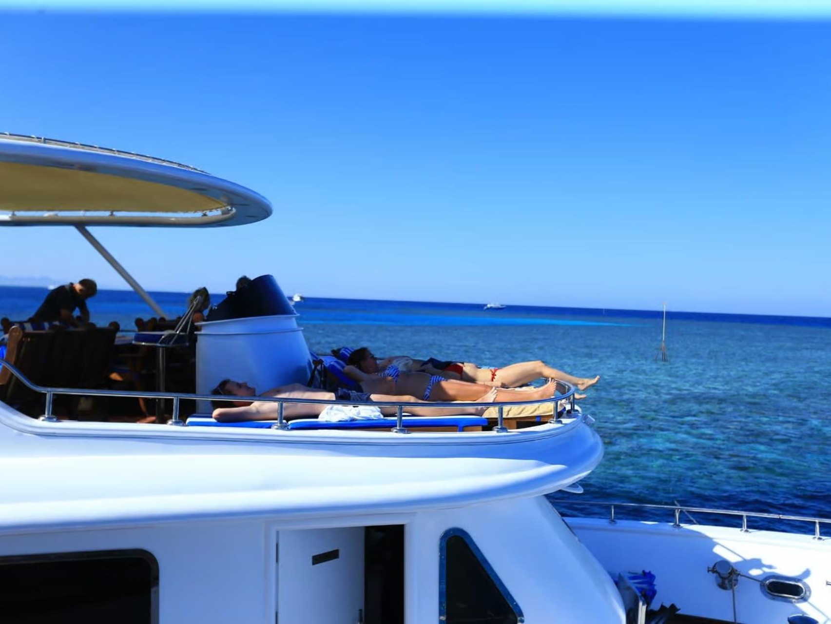 Guests relaxing on the sun deck of a boat at sea